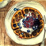 Waffles with creme, blueberries, and pomegranate